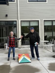 Two Meadowview of Davenport memory care residents share a joyful moment after a game of cornhole on the patio.